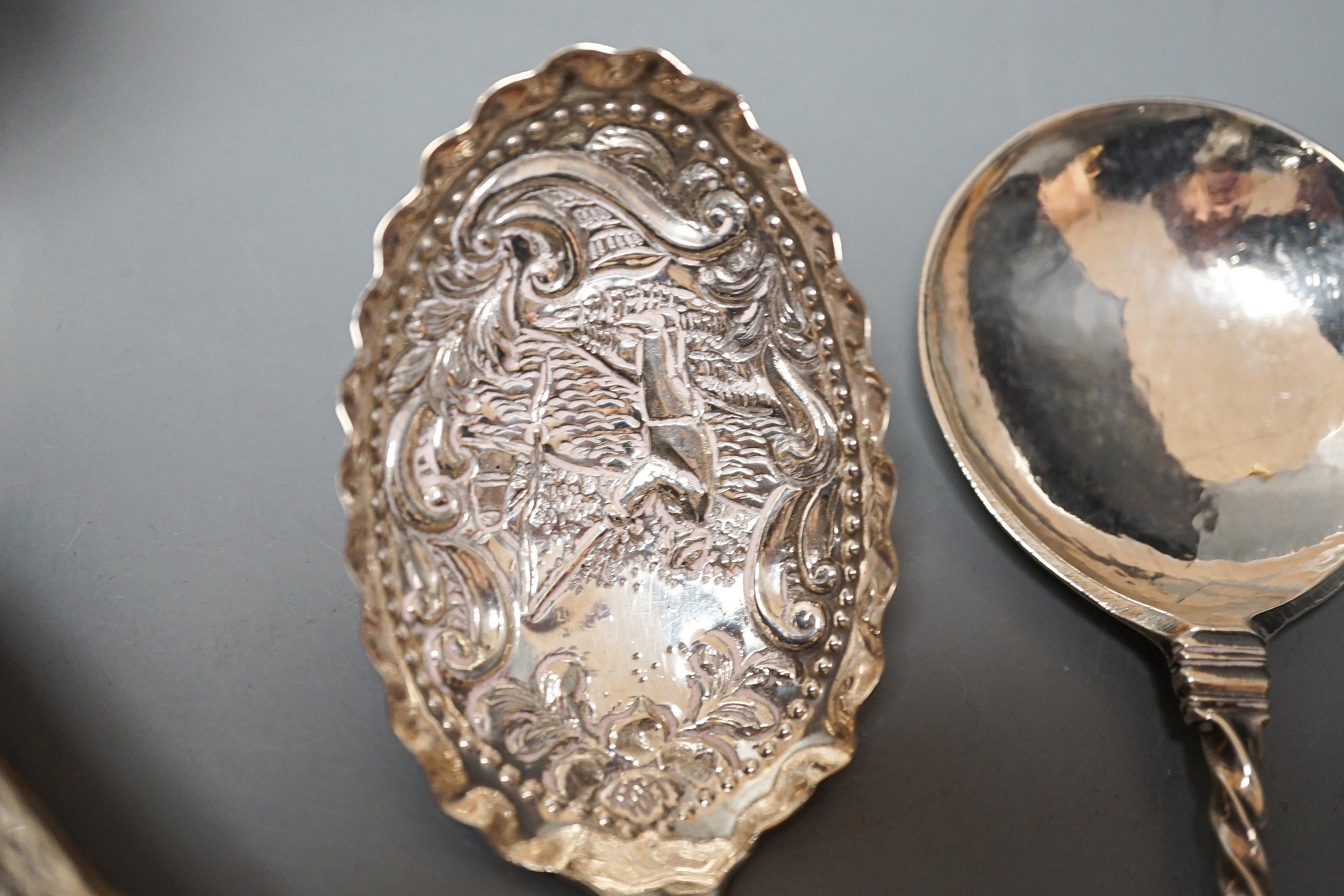 A 19th century Dutch embossed white metal spoon, 13.5cm, one other unmarked white metal spoon, a small silver posy vase and a repousse silver match sleeve.